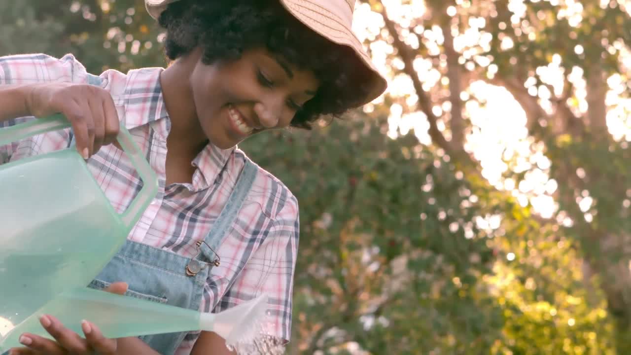 mujer joven regando las plantas bastante