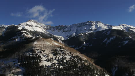 aerial cinematic drone from above view of telluride mountain ski resort downtown colorado of scenic mountains landscape early sun light mid winter pan down to the right movement