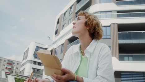 woman eating lunch outside a modern building