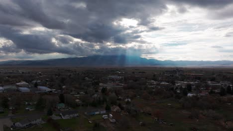 Aufsteigende-Drohnenaufnahme-Einer-Ländlichen-Stadt-In-Idaho-Mit-Sonnenstrahlen-In-Der-Ferne