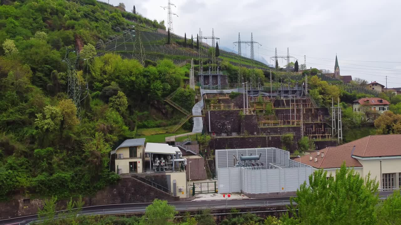 Electrical inftastructure near Bolzano township and mountains in Italy, aerial view
