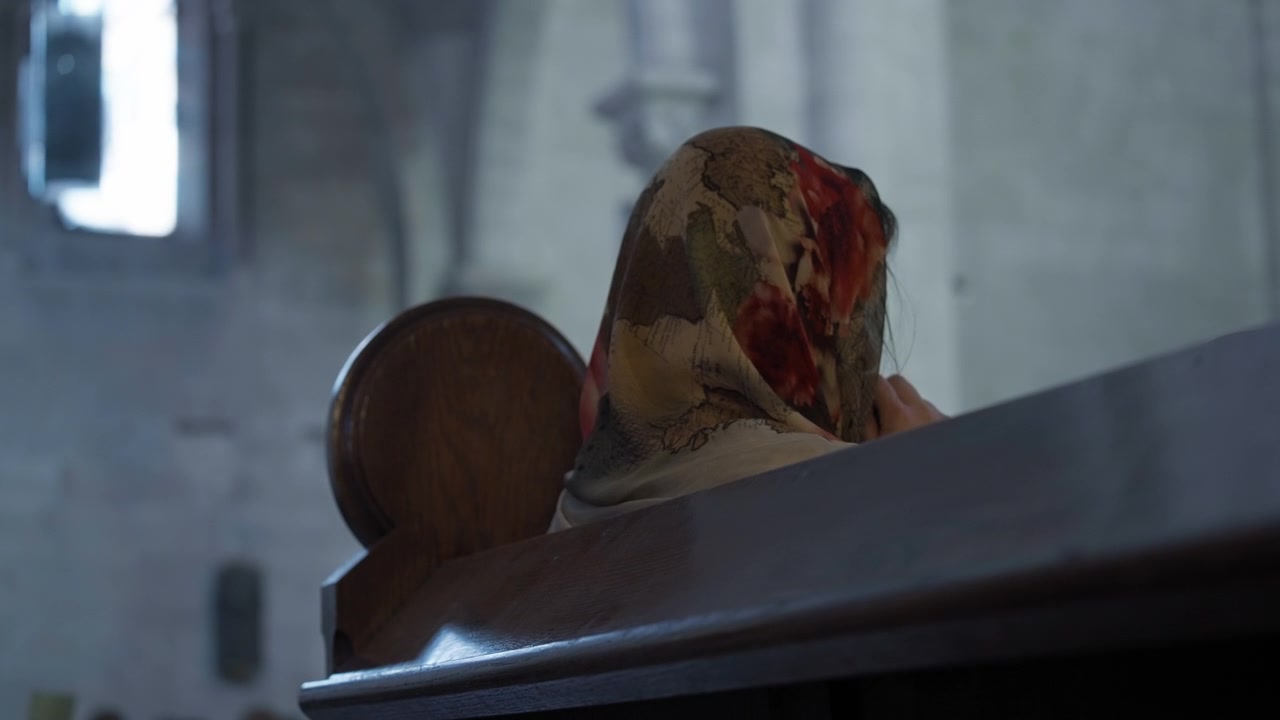 Woman praying on the church bench