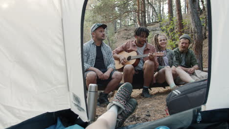 friends camping and playing music in the forest