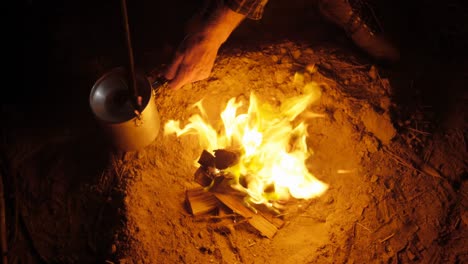 man cooking food on campfire in the forest 4k