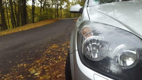 car in autumn forest woods