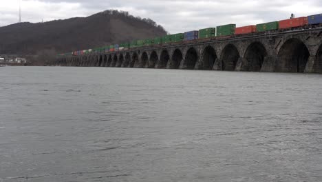 harrisburg, pennsylvania - 7 de enero de 2021: tren cruzando un puente de piedra sobre el río susquehanna cerca de harrisburg, pennsylvania