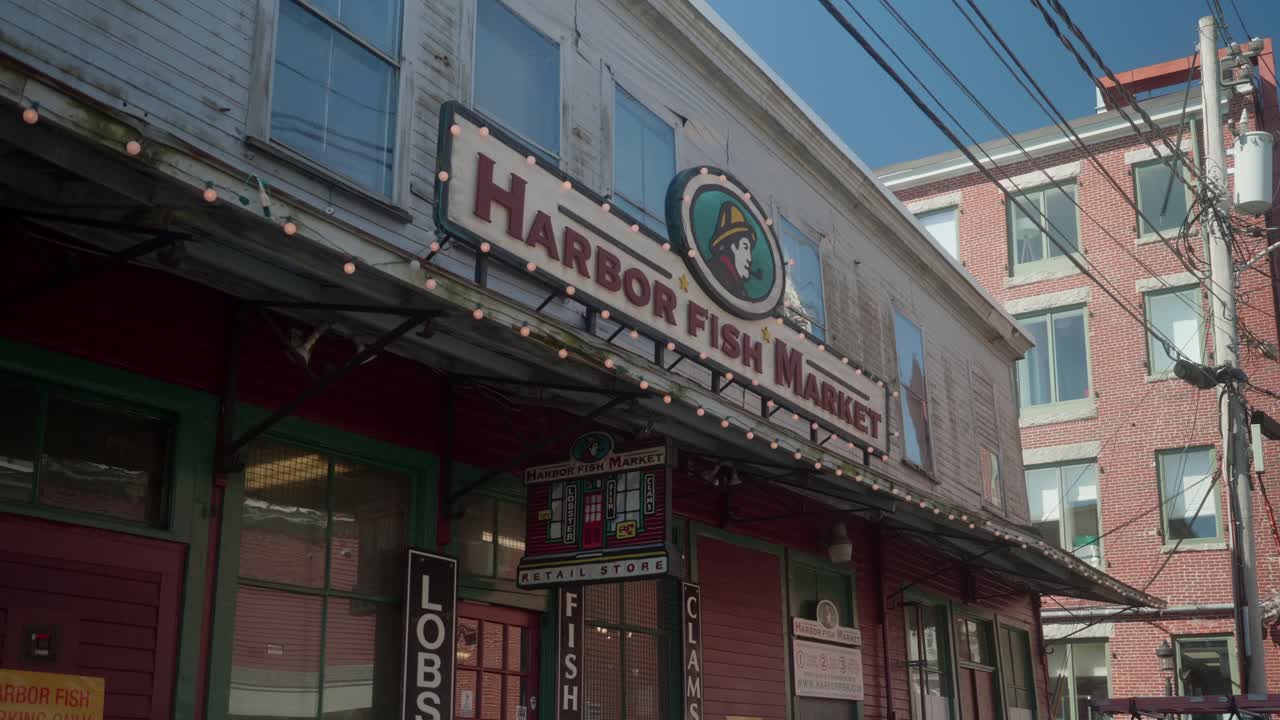 Historic brick buildings along a quiet street with scenic waterfront views nearby, fish market near the coast