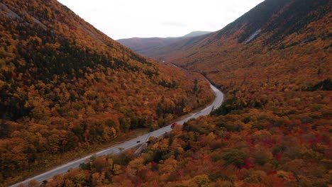 Antenne-Der-Straße-Zwischen-Zwei-Bergen,-Umgeben-Von-Herbstlaub