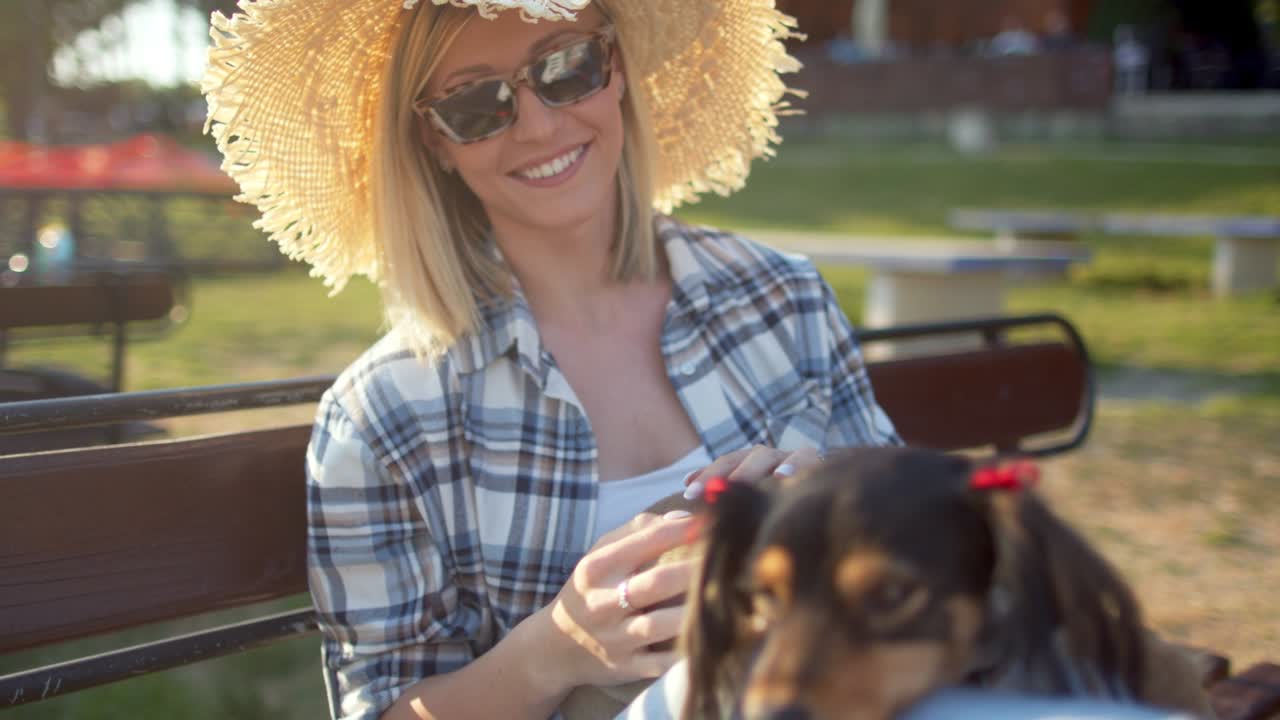 mujer joven relajándose en el banco con su perro