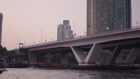 bangkok river bridge at sunset with boats