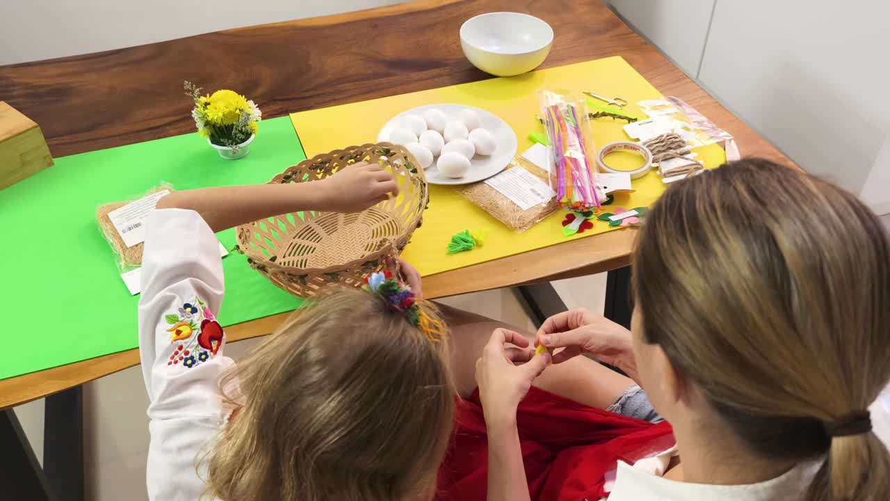 어머니 와 딸 이 부활절 바구니 장식 을 하고 있다