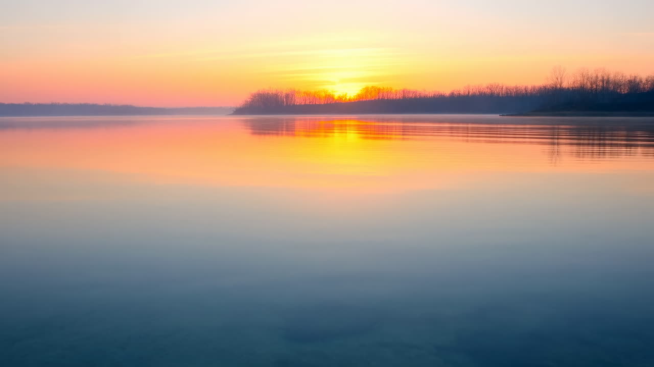 Matahari Terbenam di Atas Danau Tenang, Langit Pastel Tercermin di Permukaan, Siluet Pohon Jauh di Sepanjang Garis Pantai, Lembut