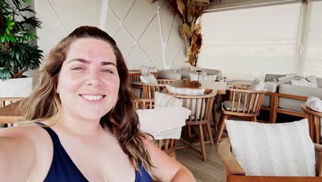 a young woman relaxing at a stylish outdoor cafe lounge after a swim