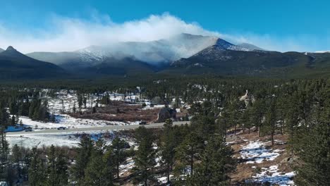 aerial dolly establishes stunning high alpine forest with epic picturesque colorado mountains above chapel