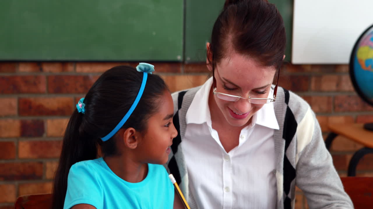 maestro ayudando a una niña durante la clase