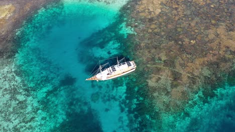 vista aérea del arrecife de coral y el barco turístico en taka makassar, parque nacional de komodo, indonesia