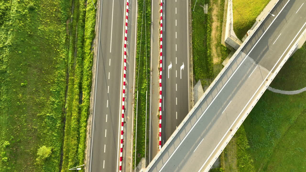 Extreme top-down aerial shot highlighting the geometric layout of an S6 expressway overpass and the lanes separated by red and white safety barriers