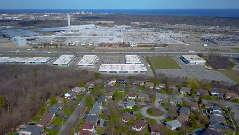 aerial over a highway, neighbourhood and industrial park in oakville, ontario, canada