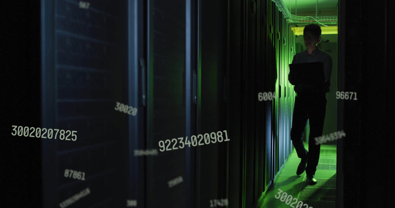 IT Professional Working on Laptop in Server Room with Digital Data