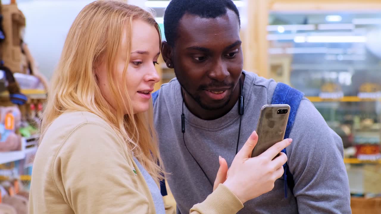 Exciting Moments Captured: Two Friends Share a Joyful Selfie in a Colorful Store Environment, Creating Lasting Memories with Their Smartphone