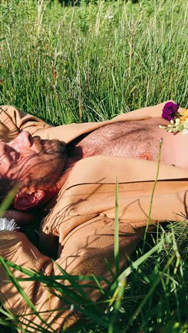 man relaxing in a meadow with flowers