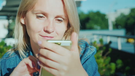 Porträt-Einer-Frau-Mit-Smartphone-Entspannen-Sie-Sich-Auf-Der-Sommerterrasse-Im-Café-4k-Video