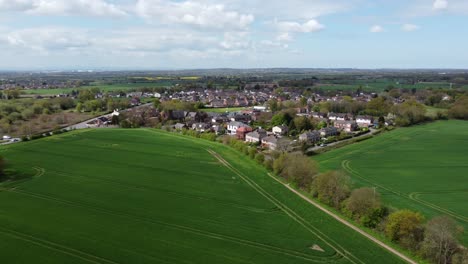 Vista-Aérea-En-órbita-Pueblo-Rural-Rural-Británico-Rodeado-De-Campos-De-Cultivo,-Cheshire,-Inglaterra