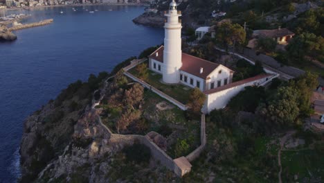 Tiro-Inclinado-Hacia-Arriba-De-Far-Des-Cap-Gros-Con-El-Puerto-De-Sóller-De-Fondo-En-Mallorca,-Antena