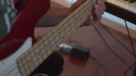 músico caucásico toca el bajo en el estudio de casa