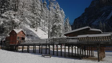 Hölzernes-Berghaus-Auf-Der-Gefrorenen-Oberfläche-Des-Pragser-Sees,-In-Den-Schneebedeckten-Dolomiten,-Italienischen-Alpen