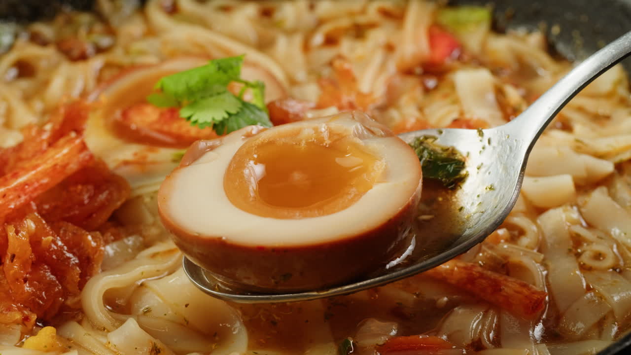 Close-up of a bowl of Asian noodle soup with a sliced egg