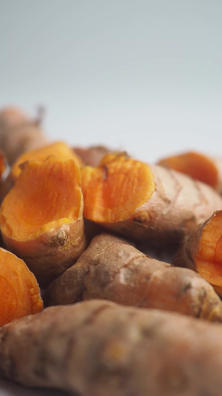 Radici di curcuma fresche su uno sfondo bianco