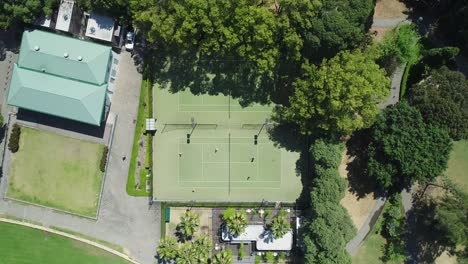 Toma-Aérea-Estática-Mirando-Directamente-Hacia-Abajo-En-La-Cancha-De-Tenis-Mientras-La-Gente-Juega