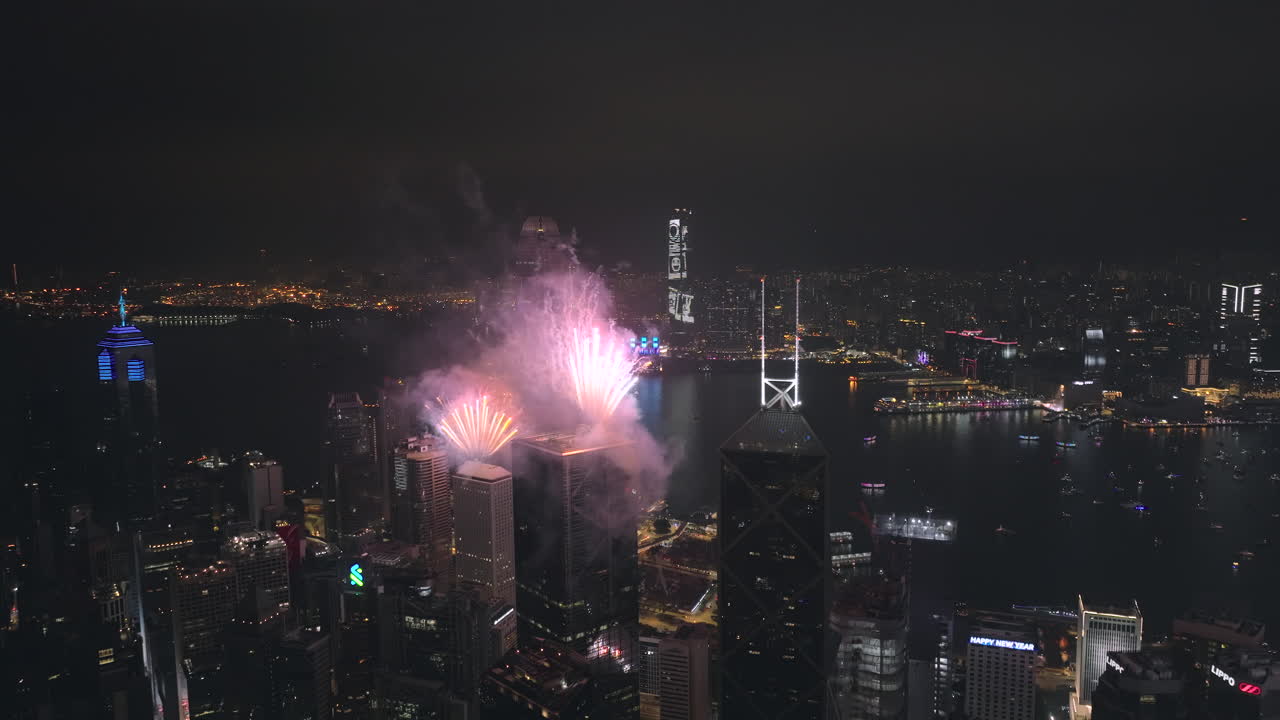 gran angular de seguimiento lateral toma aérea de drones de un espectáculo épico de fuegos artificiales en la ciudad de hong kong por la noche