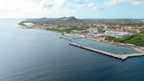 aerial ascend above empty cruise ship port dock on coastline of curacao