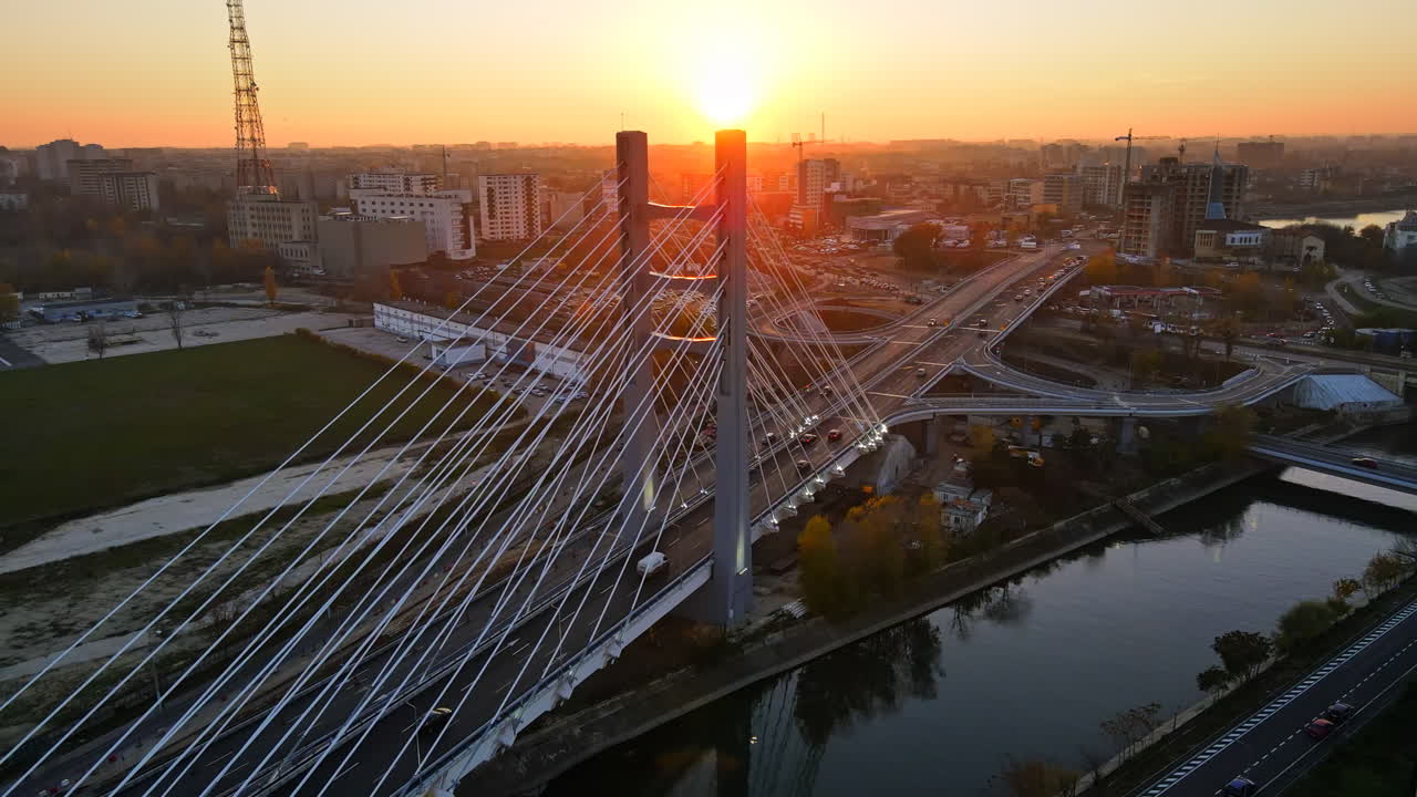 Ciurel passage, bridge over a river with moving cars, field and TV tower near it. Residential buildings on the background. View from the drone, sunset. Bucharest, Romania