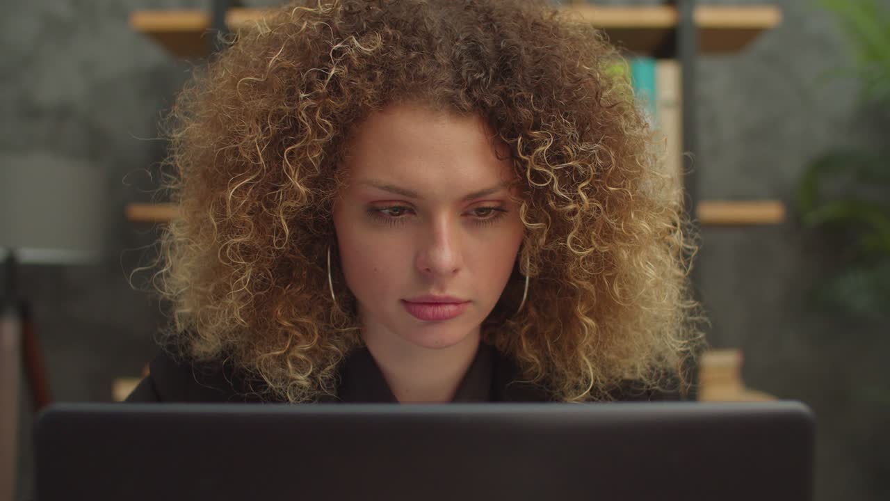 Close-up of concentrated woman working on business project on laptop indoors