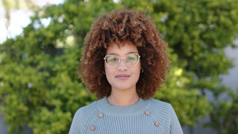 Portrait-of-happy-biracial-woman-looking-at-camera-in-garden-in-slow-motion