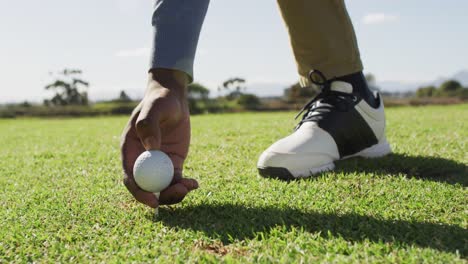 video of hands and legs of african american man playing golf on golf field