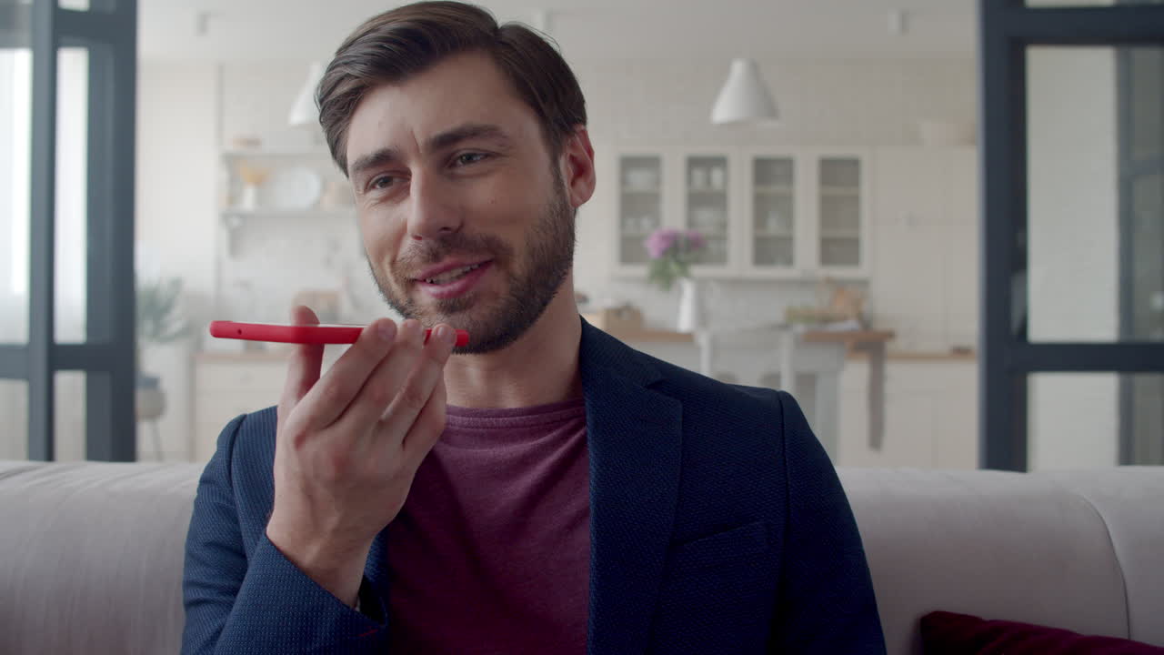 hombre de negocios sonriente grabando mensajes de voz en el teléfono en la oficina de casa