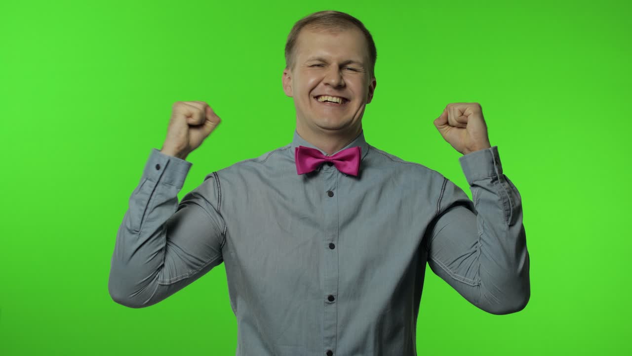 행복한 사람은 승리의 몸짓으로 주먹을 들어 올리고, 춤을 추고, 큰 성공을 축하하며, 행운의 날을 즐기고 있습니다.