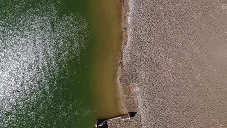 Cracked-ground-by-the-water-with-ruined-houses