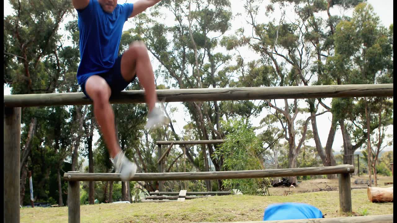 hombre y mujer en forma escalan un obstáculo durante una carrera de obstáculos