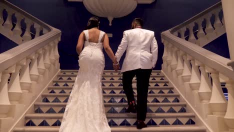 a bride and groom walking up a set of stairs at an indian wedding