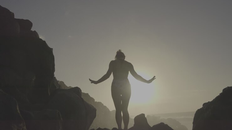 Donna che si gode il tramonto sulle rocce