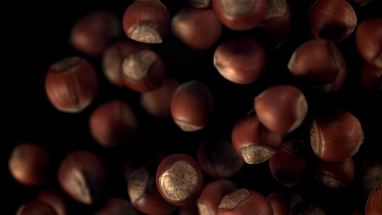 Nocciole che cadono in super slow motion su sfondo nero