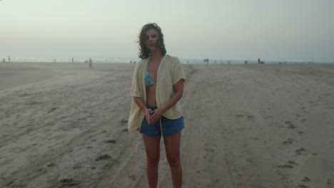 woman stretching on a beach at dusk, warm tones and a relaxed vibe, casual wear