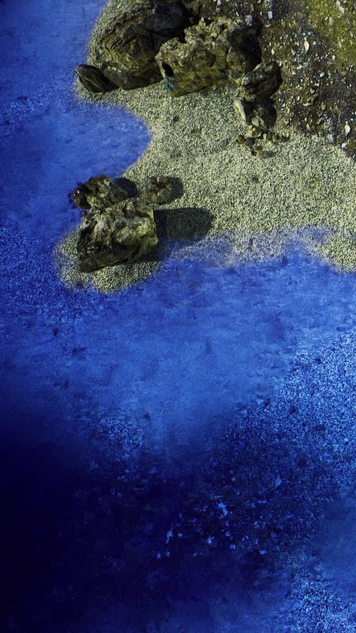 Calm blue water meets rocky shore in a scenic natural landscape during daylight