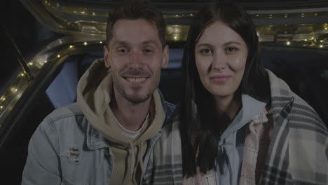 happy couple inside a car at night