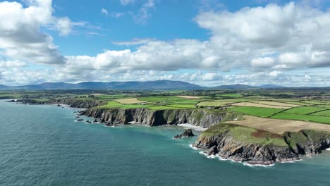 drone flying to the coast of ireland at copper coast waterford on a bright summer day